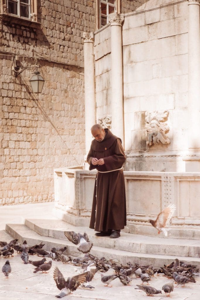 Monk feeding birds at Dubrovnik