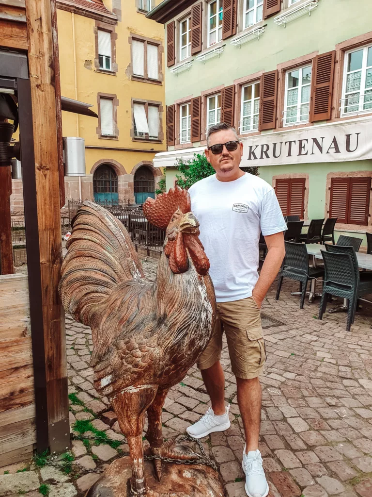 Mike and a rooster statue in Colmar