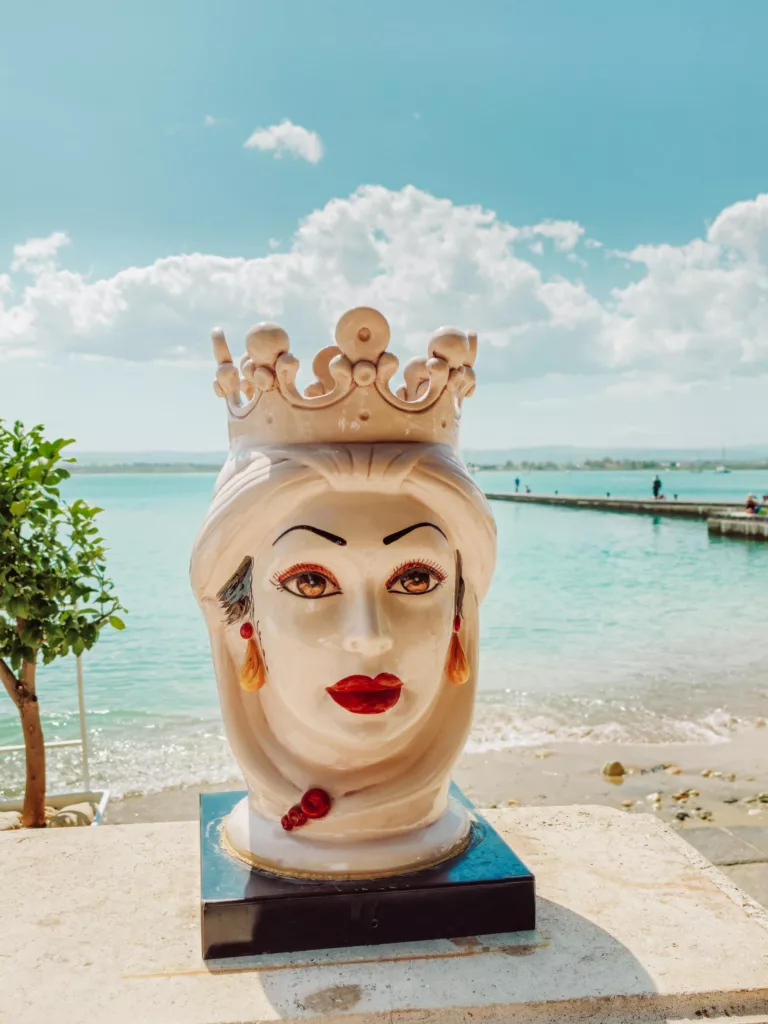Sicilian head statues at the beach off the Lungamore Ortigia